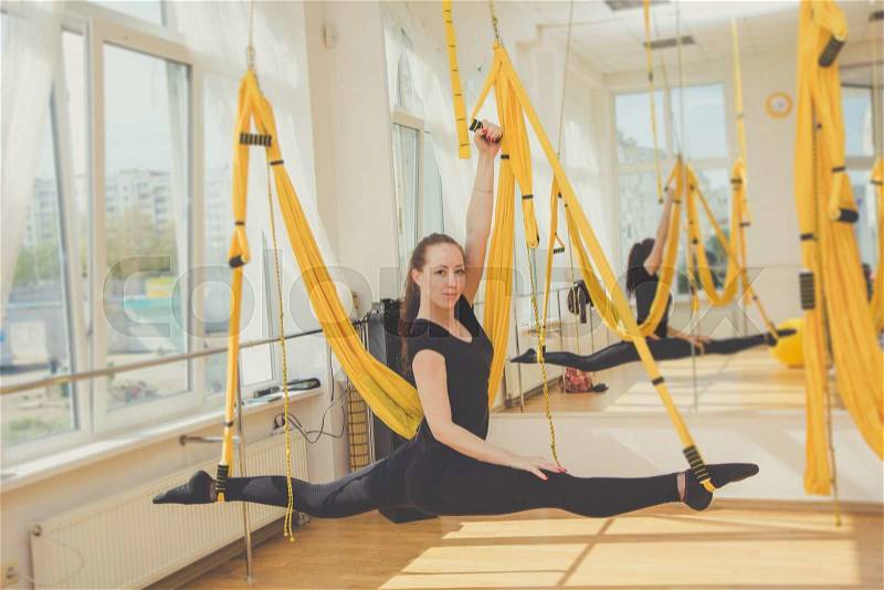 Girl doing twine on trx fitness straps, crossfit, stock photo