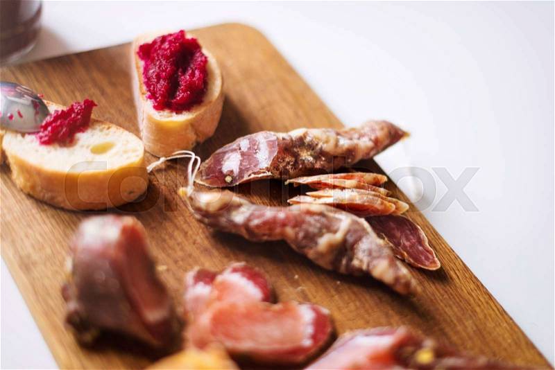Top view horizontal image of various meats on serving board with ham, pork, beef and homemade bread with beetroot-horseradish spread on rustic wood. Selective focus, stock photo