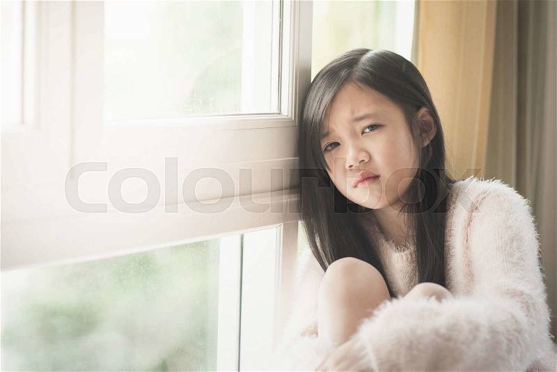 Portrait of asian beautiful sad girl at the window,vintage filter, stock photo
