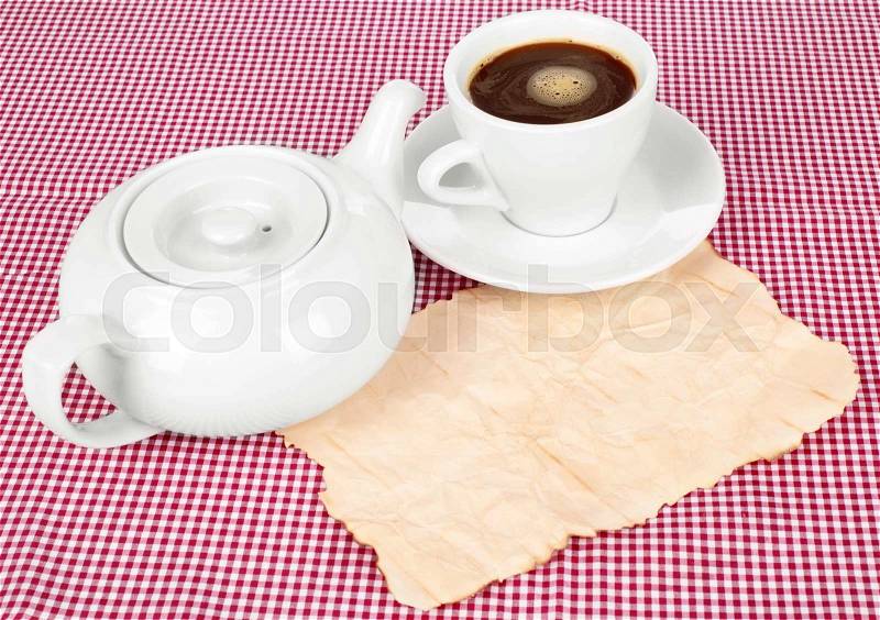 Cup of coffee with a teapot on white tablecloth, stock photo