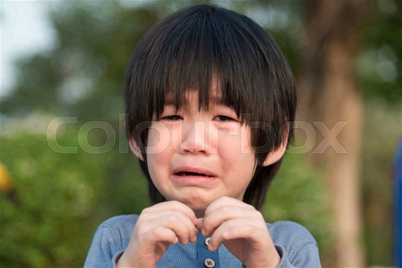 Portrait of asian boy crying in the park, stock photo