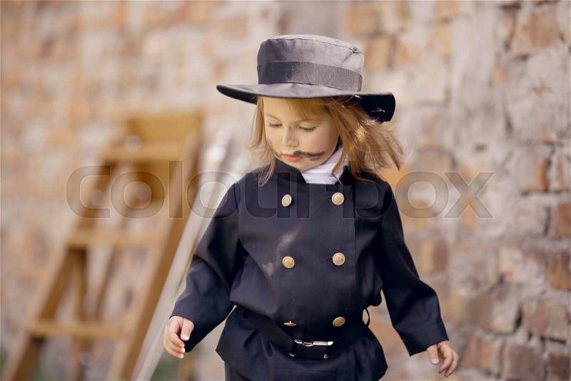 Girl as a chimney sweep against brick wall. , stock photo