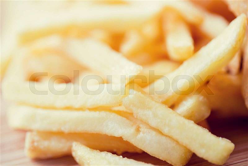 Junk-food, fast food and eating concept - close up of french fries on table, stock photo