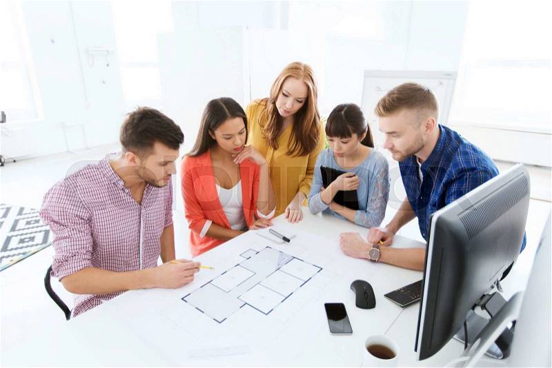 Business, startup, architecture and people concept - creative architect team or students with blueprint working at office, stock photo