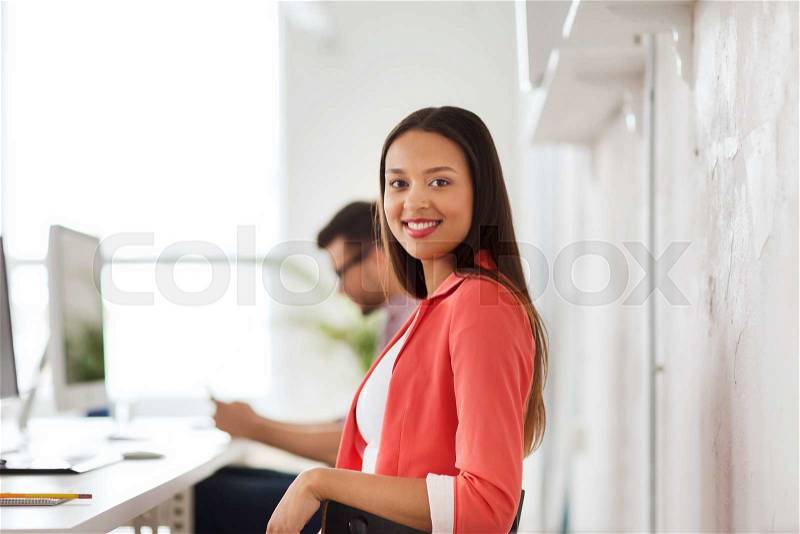 Business, startup, education and people concept - happy young african woman with computer working at office, stock photo