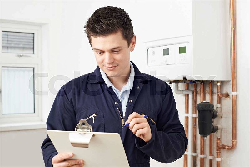 Male Plumber Working On Central Heating Boiler, stock photo