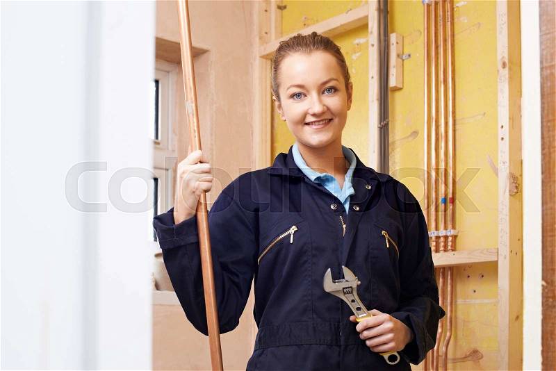 Portrait Of Female Plumber Working In House, stock photo