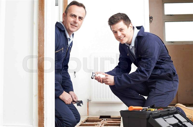 Plumber And Apprentice Fitting Central Heating, stock photo