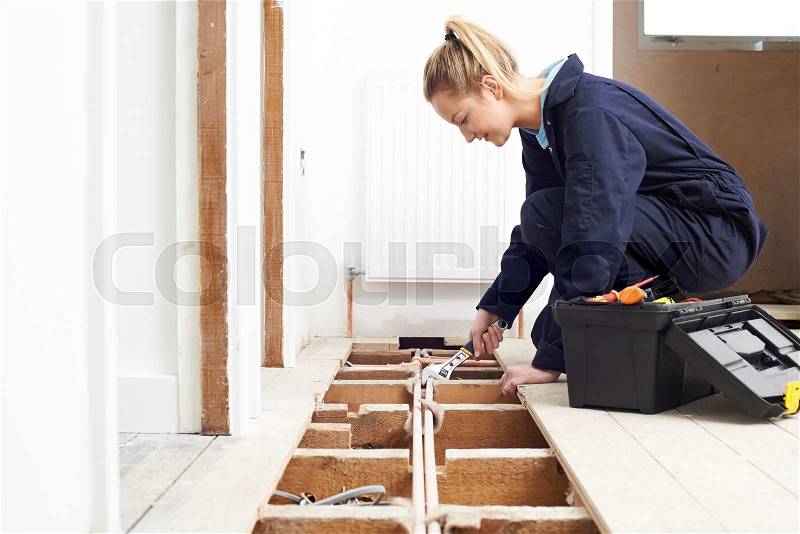 Female Plumber Fitting Central Heating System, stock photo