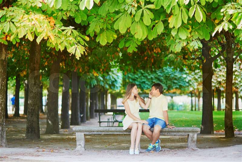 Beautiful young dating couple in Paris in the Tuileries garden on a warm and sunny autumn day, stock photo