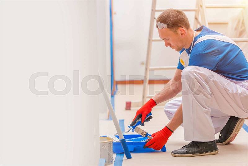 House Walls Painting. Young Caucasian Men Painting His Home. Construction and Renovation, stock photo