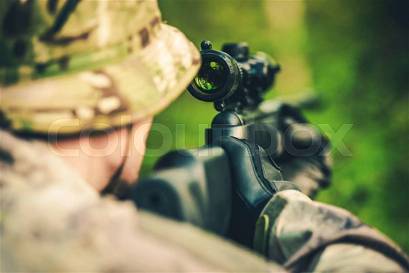 Wildlife Hunting. Camouflaged Hunter with Powerful Rifle with Scope Spotting Animals, stock photo