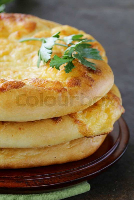 Baked flat bread with cheese on a wooden table, stock photo