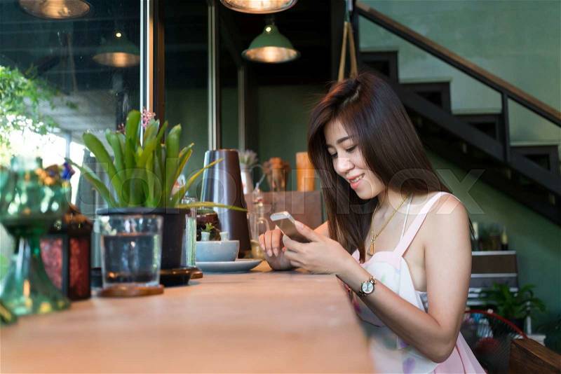 Lifestyle of women using a mobile phone in cafe coffee shop with texting message on app smartphone playing social network, stock photo