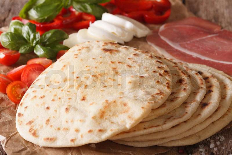 Italian piadina flat bread, ham, cheese and vegetables on a table macro. horizontal , stock photo