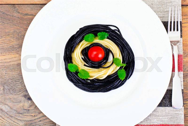 Black Spaghetti with Cuttlefish Ink, Tomato and Basil. Mediterranean and Asian Cuisine. Studio Photo, stock photo