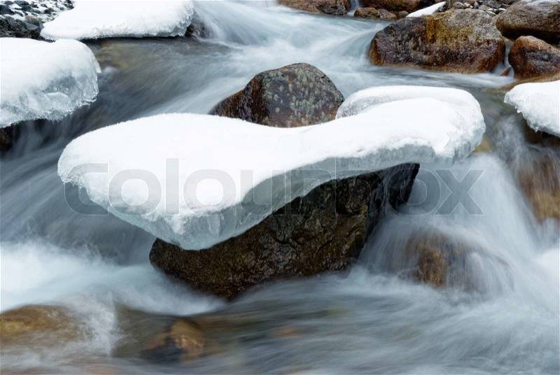 Stone in the ice and water flow, stock photo