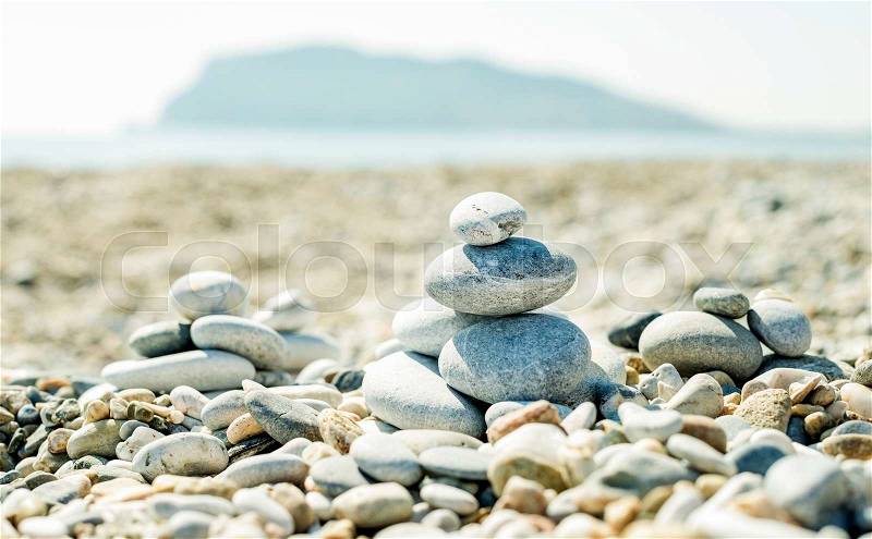 Pile of pebbles on the beach at Alanya Mediterranean sea coast, Turkey. Concept of balance, relaxation and harmony. Mount at background, stock photo