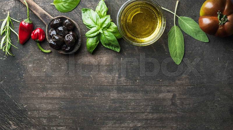 Food background with vegetables, herbs and condiment. Greek black olives, fresh basil, sage, rosemary, tomato, peppers, oil on dark rustic wooden background. Top view, copy space, stock photo