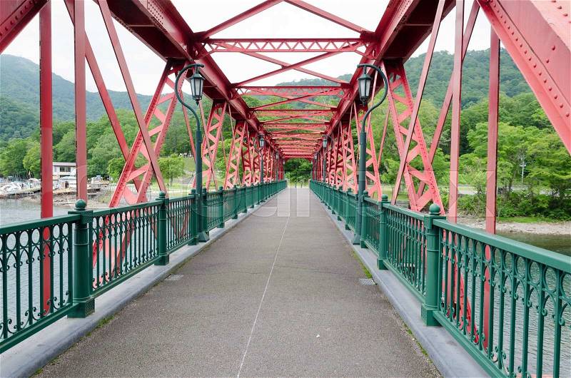 Structure of red old iron bridge over the river, stock photo