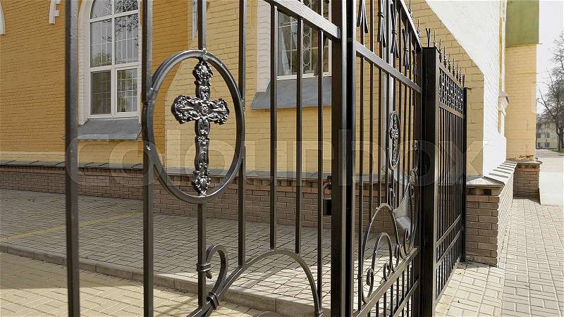 Metal fence and closed gate with cross of the churchyard. Closeup shot. , stock photo