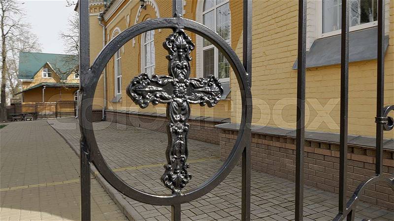Metal fence and closed gate with cross of the churchyard. Closeup shot. , stock photo