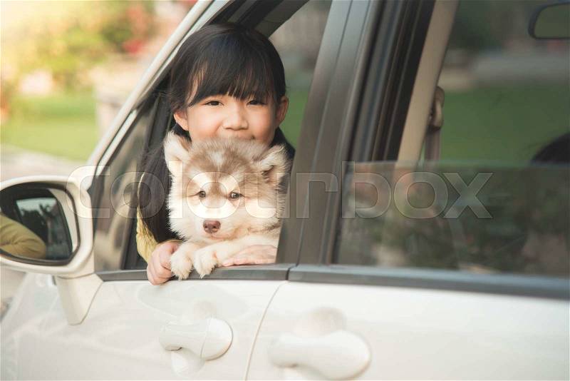 Happy asian asian girl and siberian husky puppy sitting in the car, stock photo