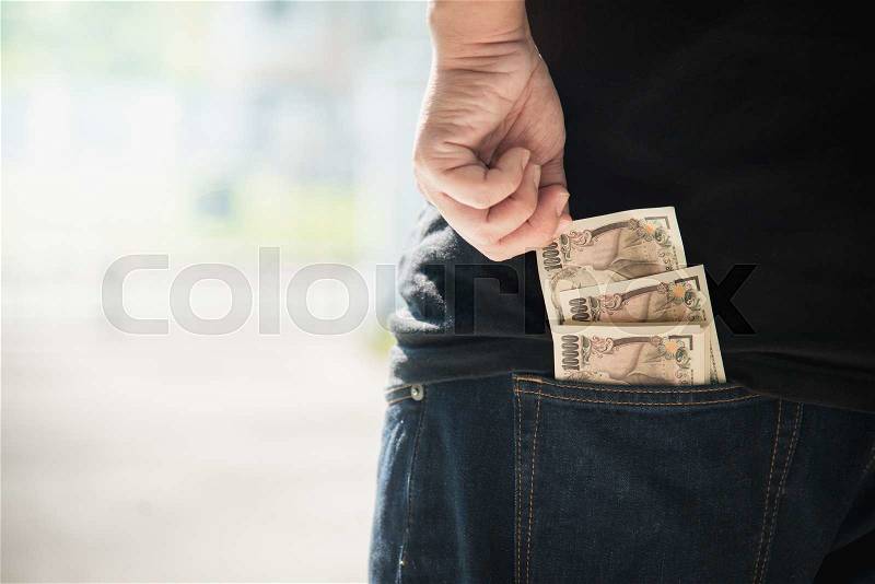 Asian man\'s hand pick pack of japanese banknotes from jeans back pocket, stock photo