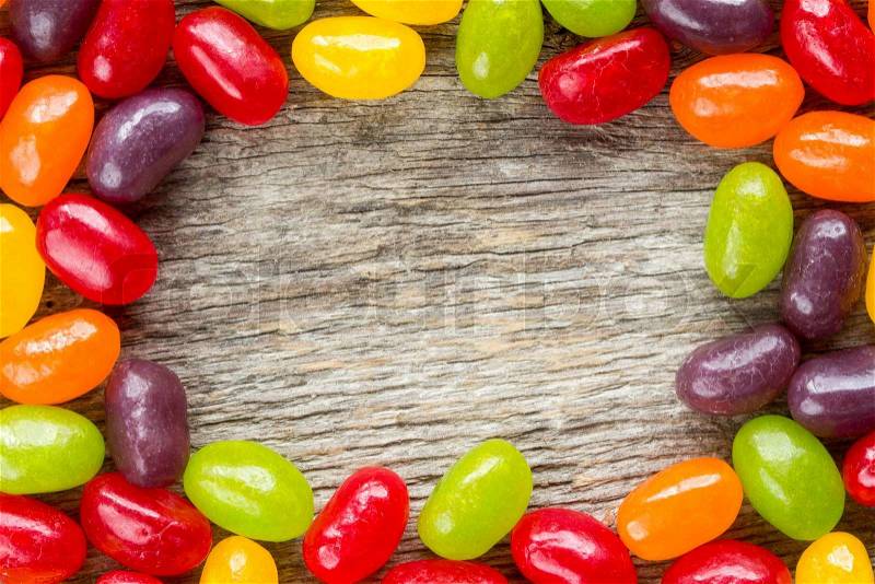 Wooden background with colorful candies frame. Copy-space, stock photo