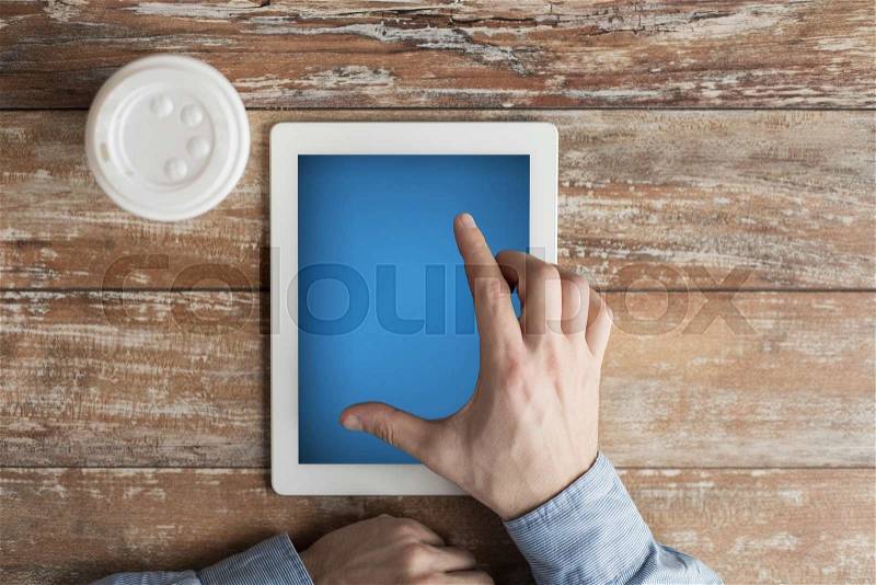 Business, education, people and technology concept - close up of male hands with tablet pc computer and coffee paper cup on table, stock photo