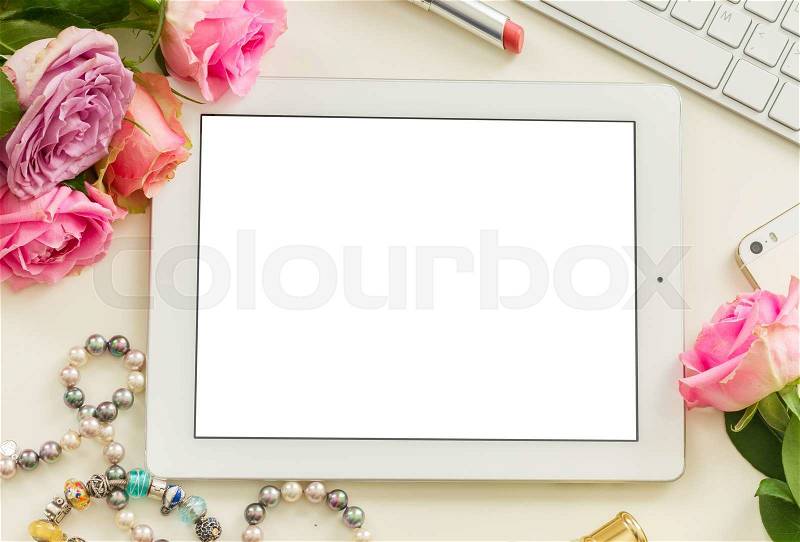 Styled desktop scene with white tablet, mobile and pink flowers, stock photo