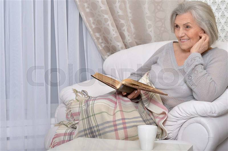 Portrait of beautiful senior woman with book, stock photo