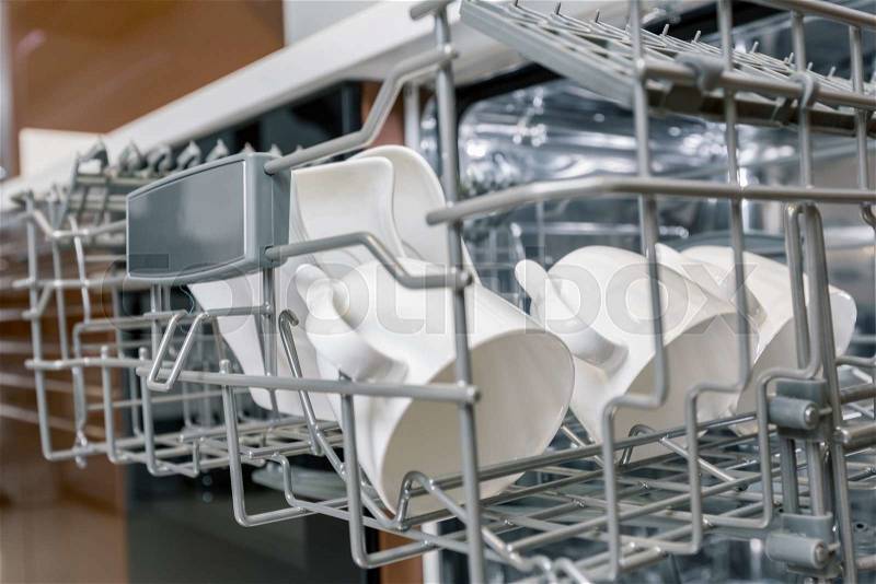 Clean dishes in open dishwasher machine, stock photo