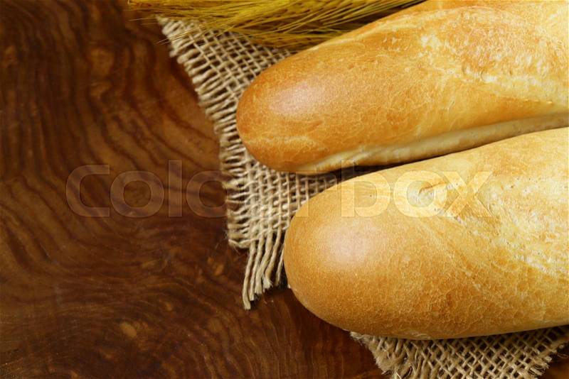 Fresh French baguette (bread) on wooden background, stock photo