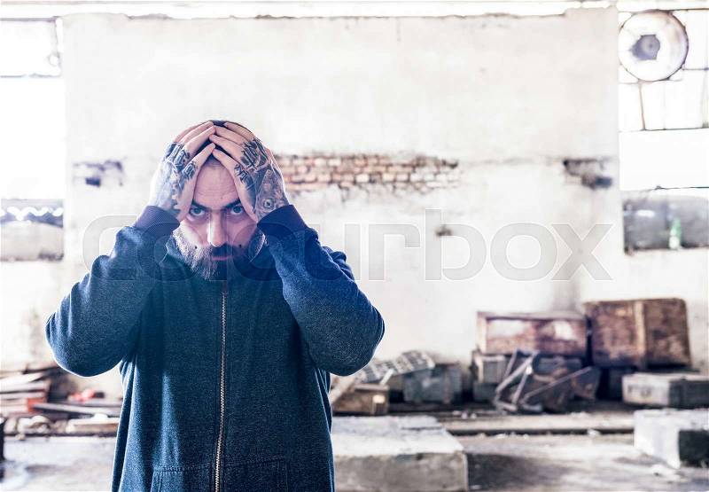 Tattooed man holding hands on his head,selective focus , stock photo