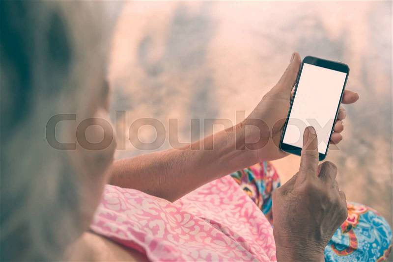Woman elderly Using a Smart Phone. Vintage filter, stock photo