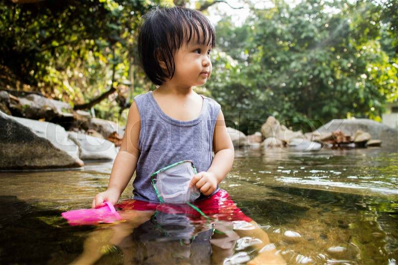 Asian Little Chinese Girl Playing in Creek in the Forest, stock photo