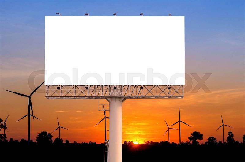 Blank billboard with wind turbine at sunset time for advertisement, stock photo