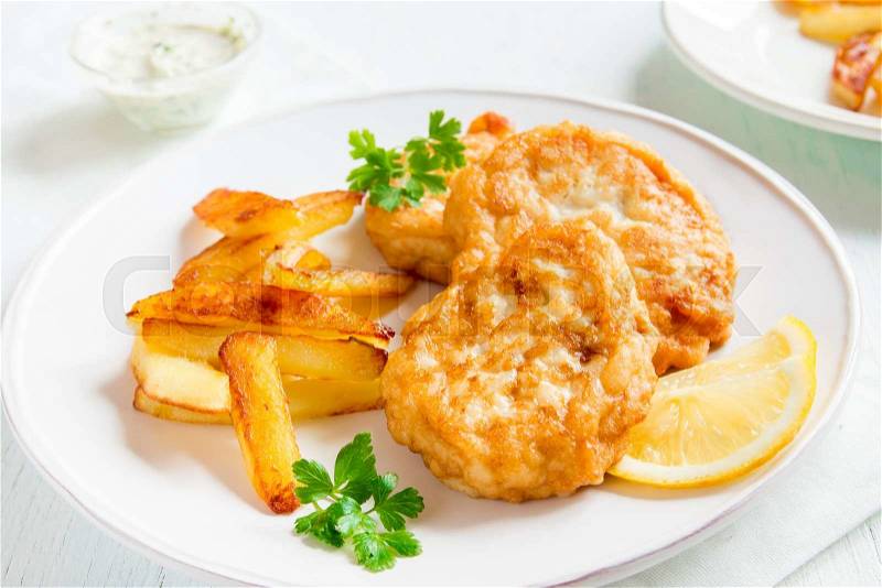Homemade fish cakes with french fries on white plate close up, stock photo