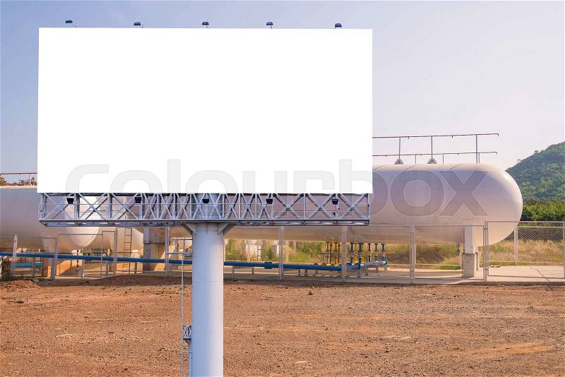 Blank billboard for advertisement with Natural Gas storage tanks in industrial plant, stock photo