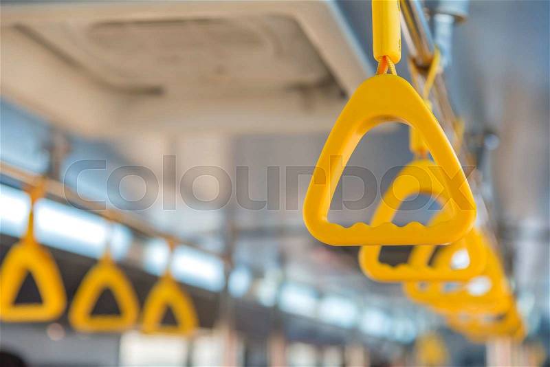 Handles on ceiling for standing passenger inside a bus, stock photo