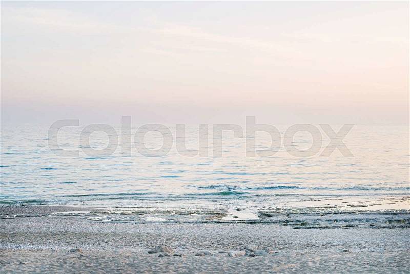 Peaceful scene of a calm sea at sunset, pastel colors, stock photo
