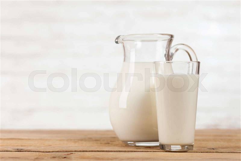 Milk jar on a wooden table, stock photo