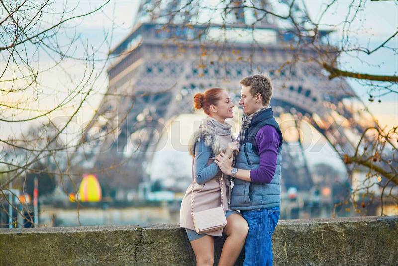 Young romantic couple near the Eiffel tower at early morning in Paris, France , stock photo