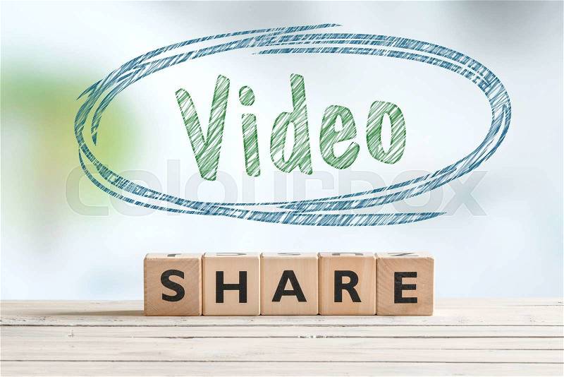 Share video sign on a wooden table with a sketch, stock photo