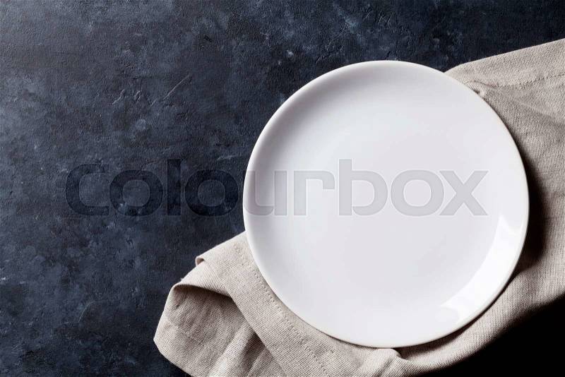 Empty plate and towel over stone table. Top view with copy space, stock photo