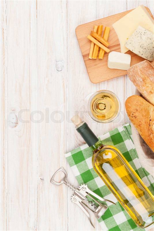 White wine, cheese and bread on white wooden table background. Top view with copy space, stock photo