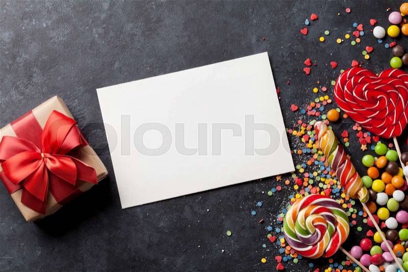 Candies, gift box and greeting card on stone background. Top view with copy space, stock photo