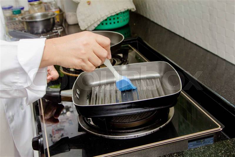 Brush with oil in a frying pan, stock photo
