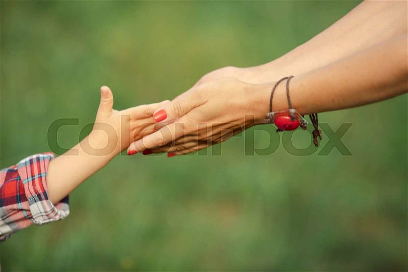 A child hand give his parent something on the nature, stock photo